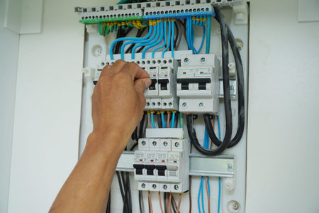 Electrician working checking a switchboard with fuses