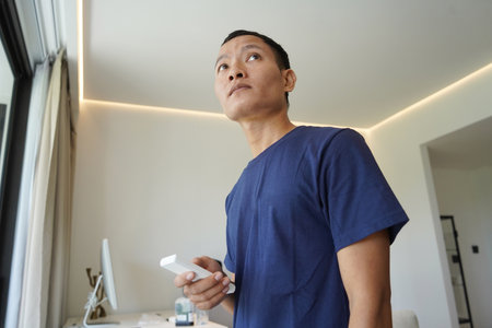 Person checking curtain control system in roomの写真素材