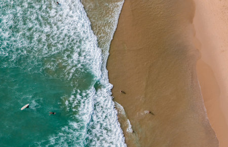 Top view beach with waves crashing on sandy shore