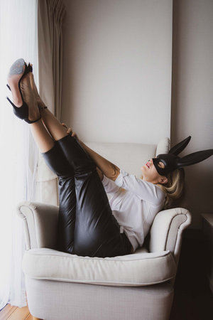 Young woman with black mask posing on the chairの写真素材