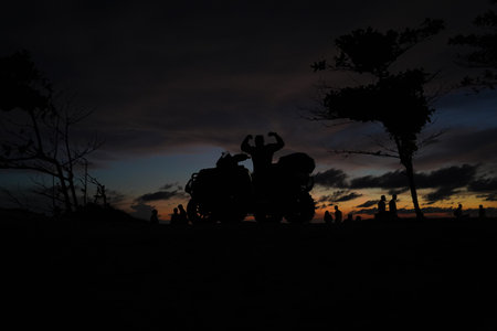 A man engages in extreme ATV riding on mountains in the evening
