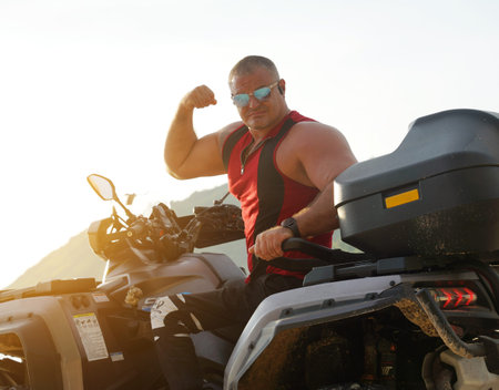 A man engages in extreme ATV riding on sand beach early in the morning