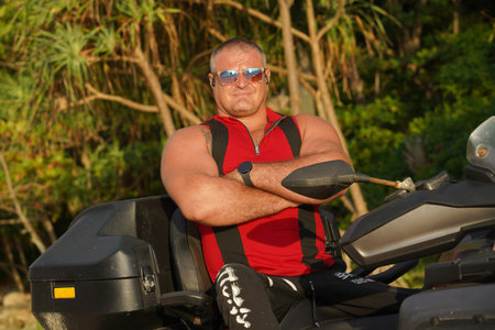 A man engages in extreme ATV riding on sand beach early in the morning