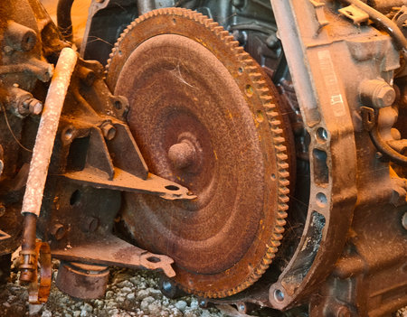 Rusted engine parts and corroded gears scattered across the sandy ground