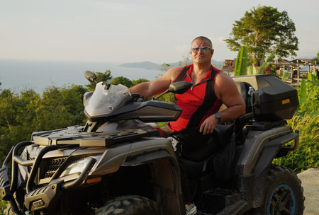 A man engages in extreme ATV riding on mountains in the evening