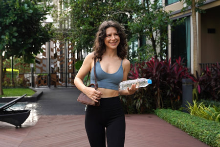 Sport female walking in bustling city space with plants