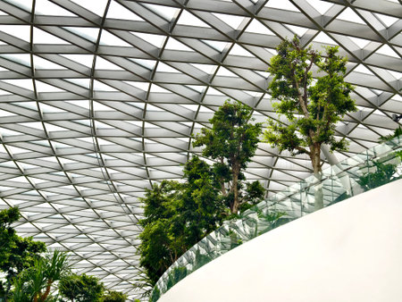 Contemporary glass enclosed indoor garden filled with abundant verdant foliage and sunlight