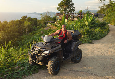 A man engages in extreme ATV riding on mountains in the evening