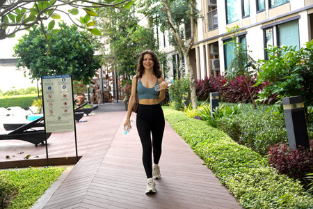 Sport female walking in bustling city space with plants