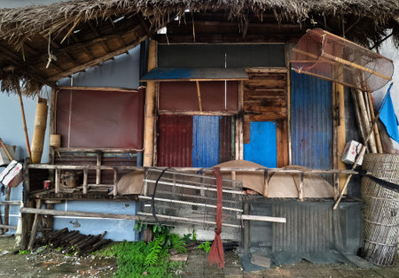 Weathered wooden beachfront shack with blue shutters, thatched roof, rusted panels