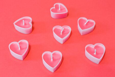 pink candles in the form of a heart on a red background for Valentine's day . High quality photoの写真素材