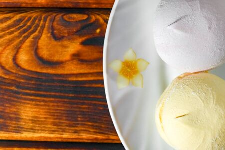 colorful marshmallows on a plate on a wooden backgroundの写真素材