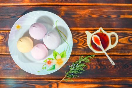 colorful marshmallows on a plate on a wooden backgroundの写真素材