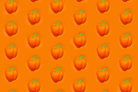 colorful vegetable pattern of orange bell pepper on an orange background. the pattern of bell pepper. the view from the topの写真素材