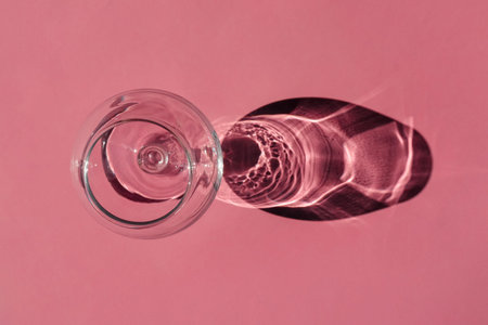 a glass with a hard shadow on a plain background. the view from the top. blank for the pattern