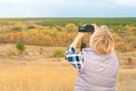 a girl with a camera shoots a landscape