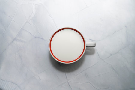 a mug of milk on the marble table. the view from the top