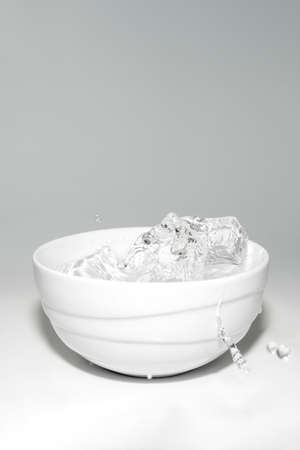water splashes in a glass with ice on a white backgroundの写真素材
