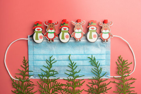 medical mask with Christmas toys and thuja branches