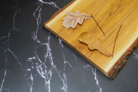 oak leaves on an oak Board on black marbleの写真素材