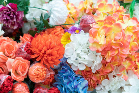 artificial multicolored flowers close up as background