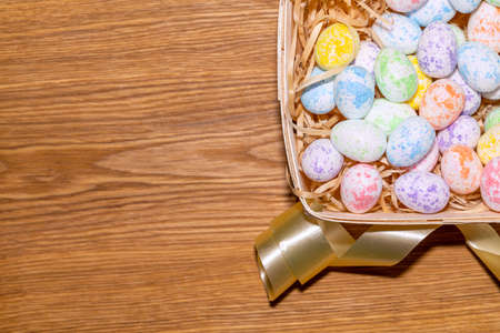 easter colorful eggs in a nest close up on a wooden backgroundの写真素材