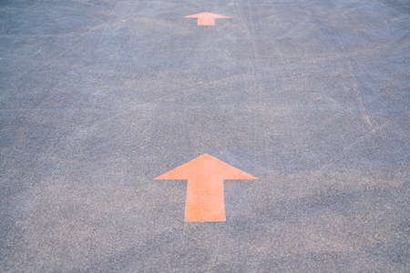 orange arrows are signs on the asphalt of the roadの写真素材