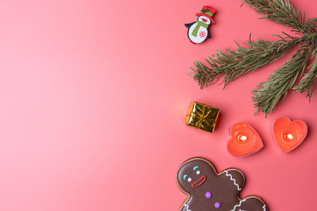 christmas toys candles and cookies on a pink background in a blur