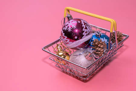 christmas toys in a supermarket basket on a pink background top viewの写真素材
