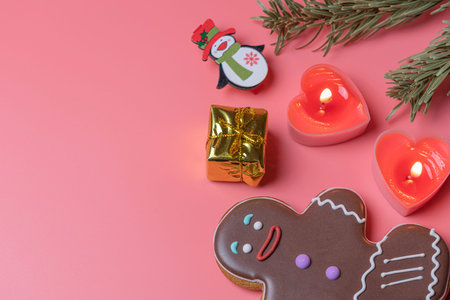 christmas toys candles and cookies on a pink background in a blur