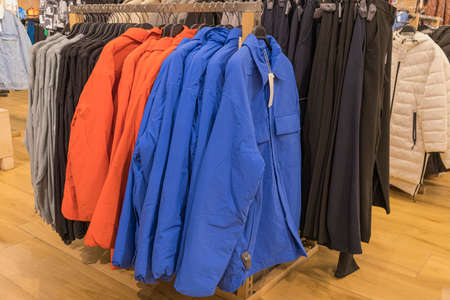 mens winter jackets on hangers in the storeの写真素材