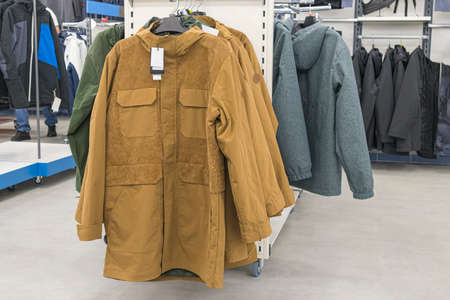 mens winter jackets on hangers in the storeの写真素材