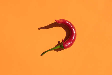 red hot pepper on a yellow background with a hard shadowの写真素材