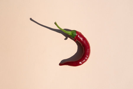 red hot pepper on a beige background with a hard shadowの写真素材