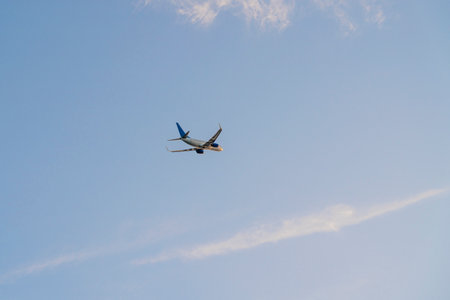 the plane is flying against the blue skyの写真素材
