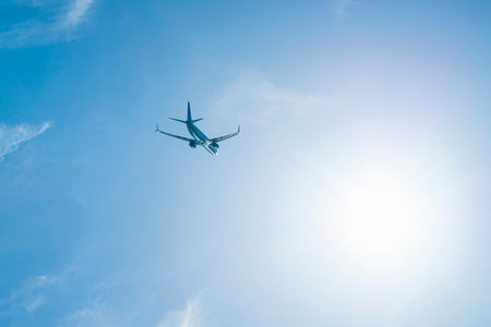 the plane is flying against the blue sky