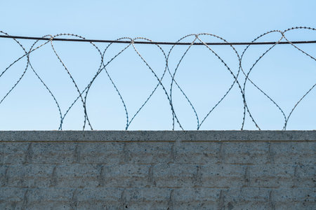 fence with barbed wire on a blue sky background