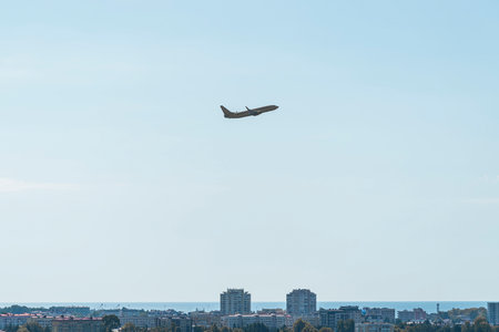 the plane is flying against a background of blue sky and sunの写真素材