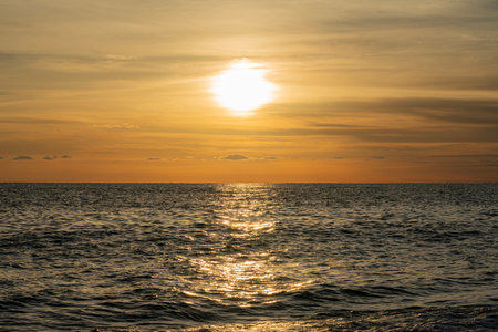 Sunset Over the Ocean With Golden Reflections Casting Serene Ambianceの写真素材
