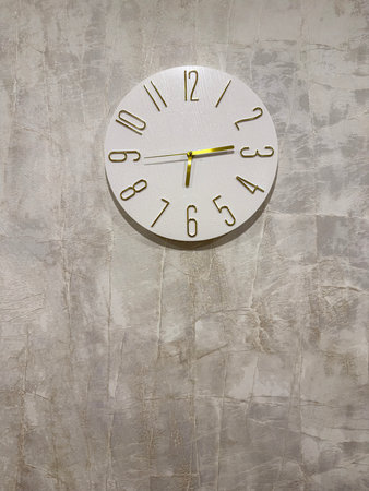 Modern Wall Clock With Minimal Design on Light Textured Backgroundの写真素材
