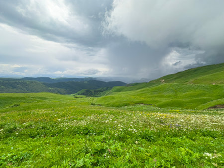 Lush Green Hillside Landscape Under Stormy Clouds.の写真素材