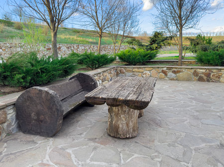 Outdoor Seating Area With Wooden Furniture in a Serene Garden Settingの写真素材
