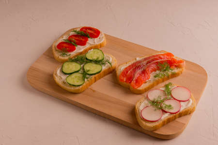 Sandwiches with trout pieces, avocado, radishes. Perfect for breakfast. On a concrete and white background.の写真素材