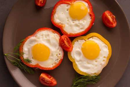 Scrambled eggs fried in rings of Bulgarian pepper with tomatoes and herbs.の写真素材