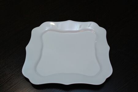 White square plate on a dark tableの写真素材