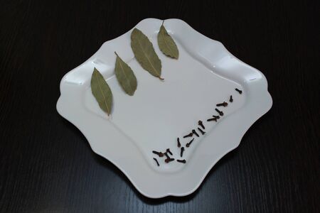 White plate with spices on a dark tableの写真素材