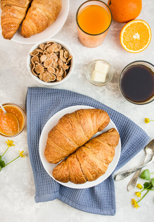 Fresh croissants with jam and coffee. European breakfast on a light table, top view. food background. copyspace.の写真素材