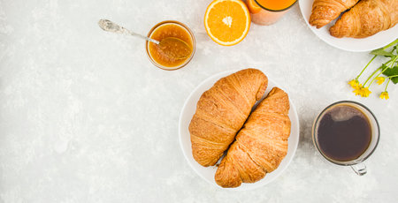Fresh croissants with jam and coffee. European breakfast on a light table, top view. food background. copyspace.の写真素材