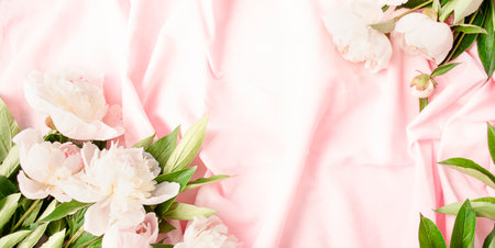 Frame of white and pink peonies on a pink fabric background. flat lay. view from above. Copy space.Place for text.の写真素材