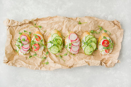 Various vegetarian sandwiches with vegetables and herbs on parchment on a light table. Proper nutrition. Diet food. food background. view from above. copyspace.の写真素材